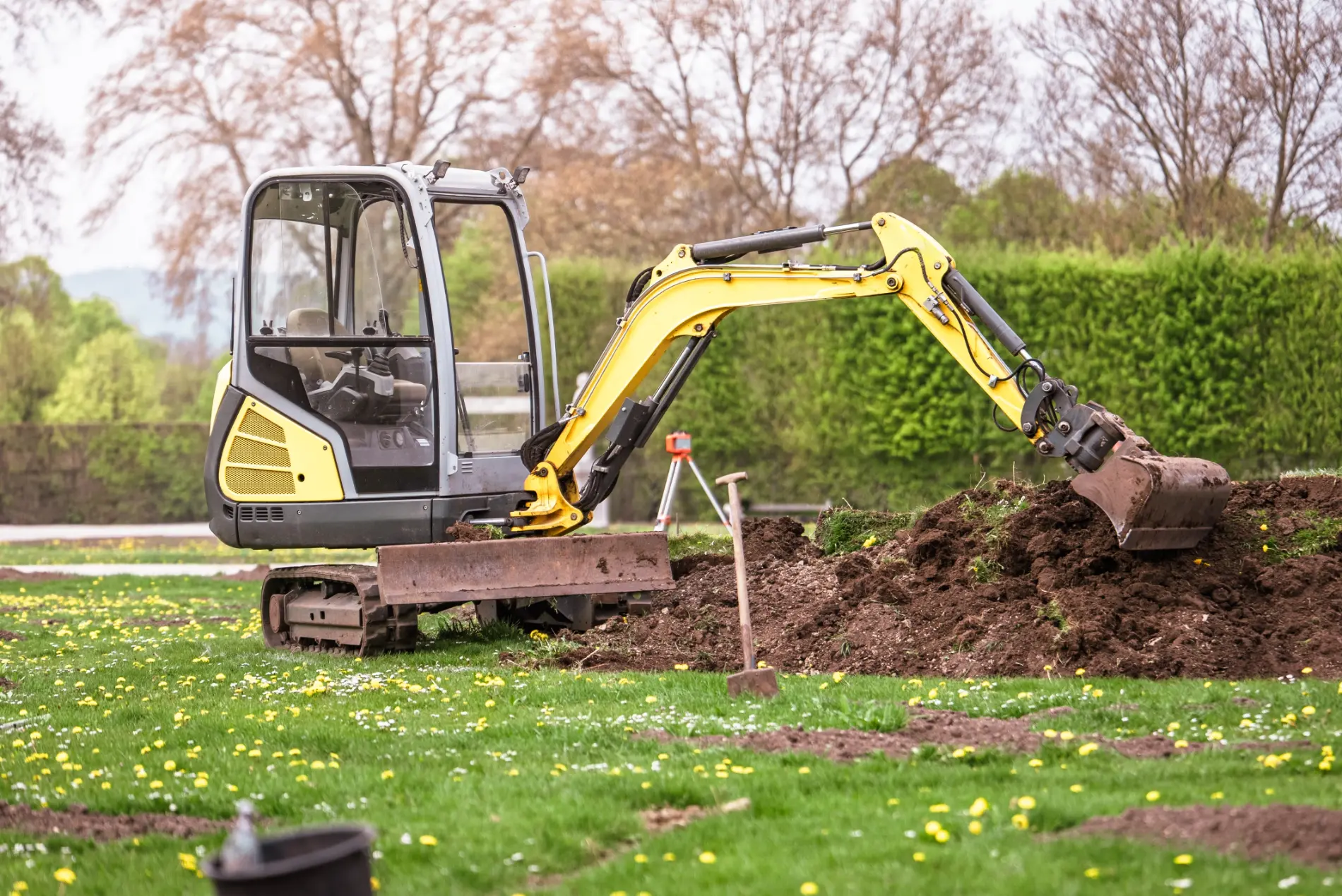 Mini excavator digging a trench in a residential yard